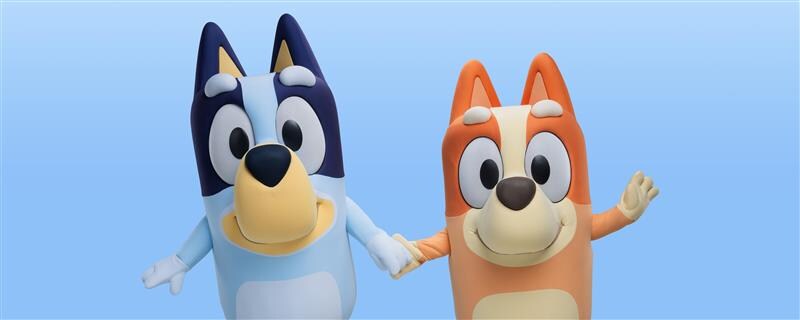 Bluey and Bingo standing together while holding hands