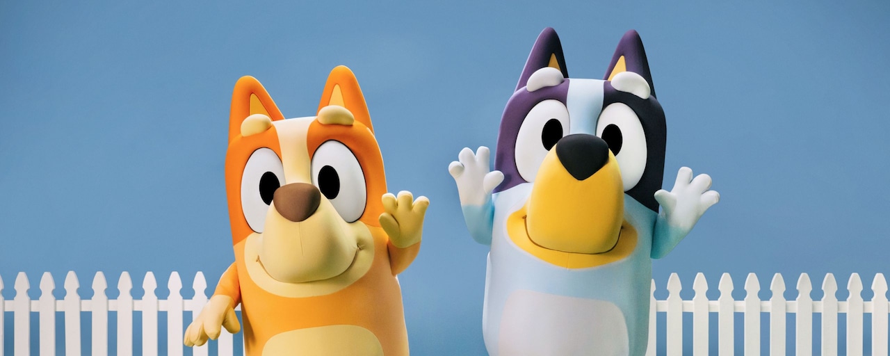 Bingo and Bluey standing together while waving