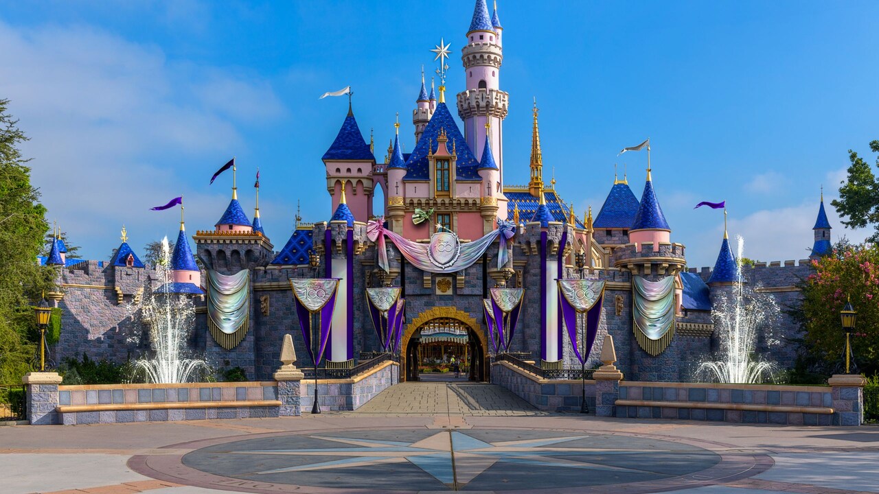 Castillo de la Bella Durmiente en el Disneyland Resort, decorado con pancartas que dicen "Disney 100"