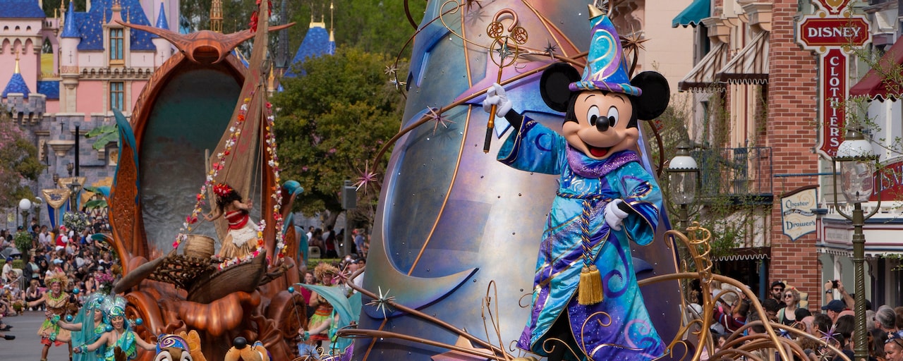 Mickey Mouse con un atuendo de mago en un carro alegórico del desfile que pasa cerca del Castillo de la Bella Durmiente"