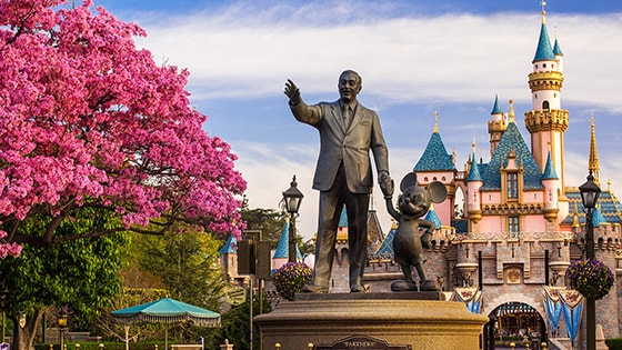 The Partners statue featuring Walt Disney and Mickey Mouse stands in front of Sleeping Beauty Castle at Disneyland Park in California