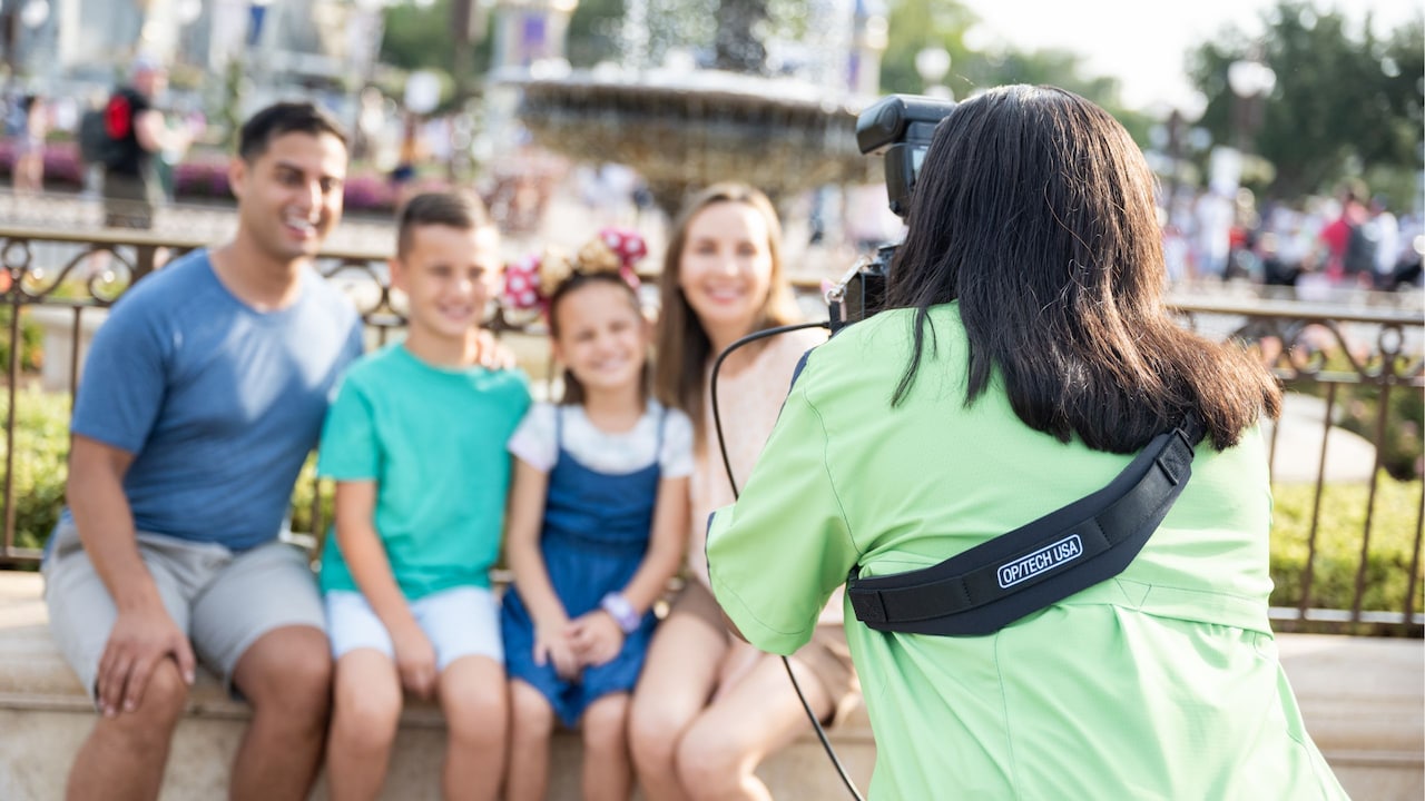 A photographer taking a picture of a family in front of Cinderella Castle at Walt Disney World Resort