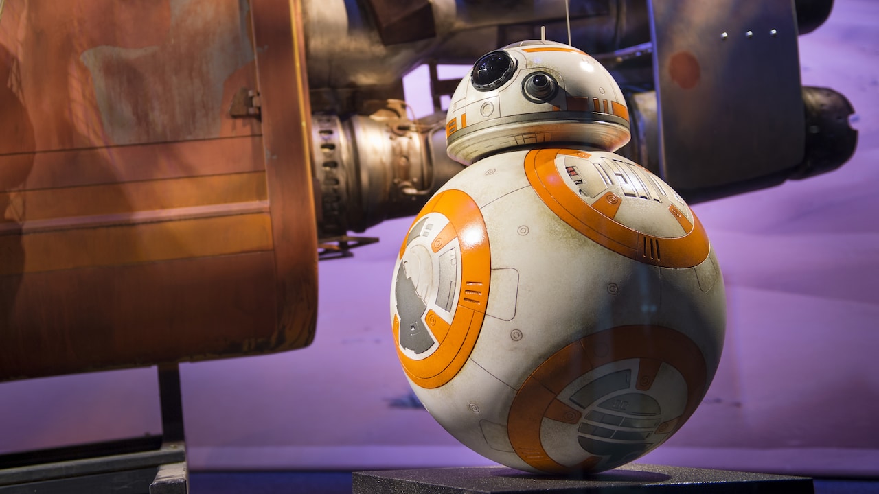 El droide BB 8 de Star Wars esta posicionado junto a una nave espacial replica