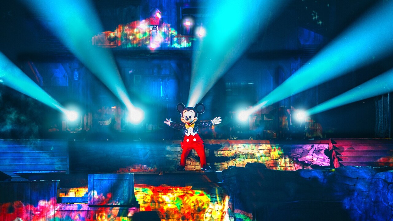  Luces proyectadas desde los dedos de Mickey mientras se presenta en un escenario durante el espectáculo de Fantasmic!