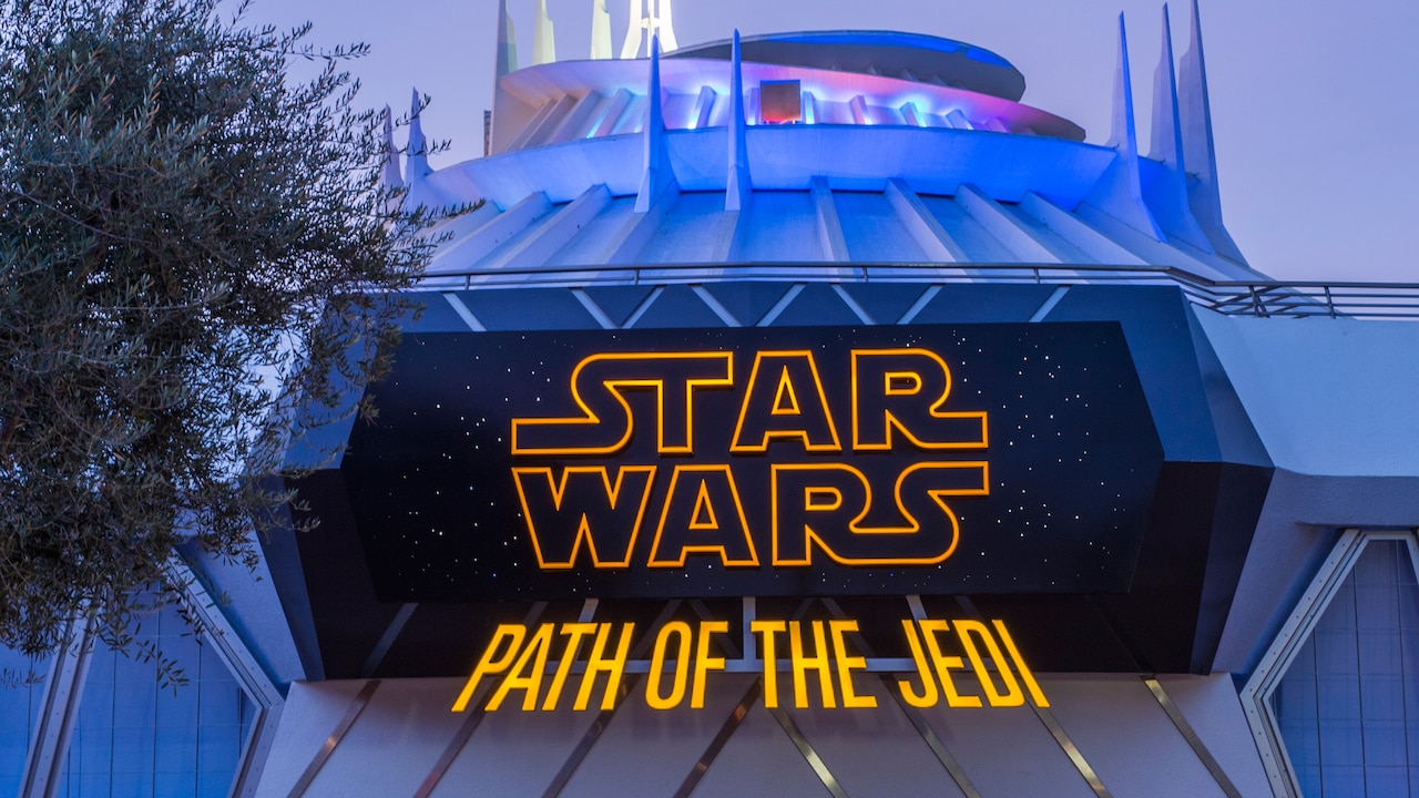 Un letrero frente a la atracción Space Mountain dice "Star Wars Path of the Jedi" con letras iluminadas