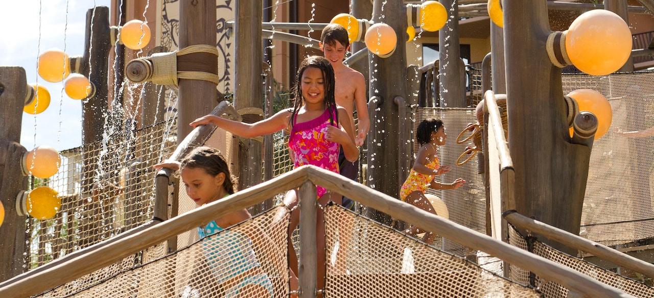 Kids of all ages laughing and playing while they make their way across the Menehune Bridge play area
