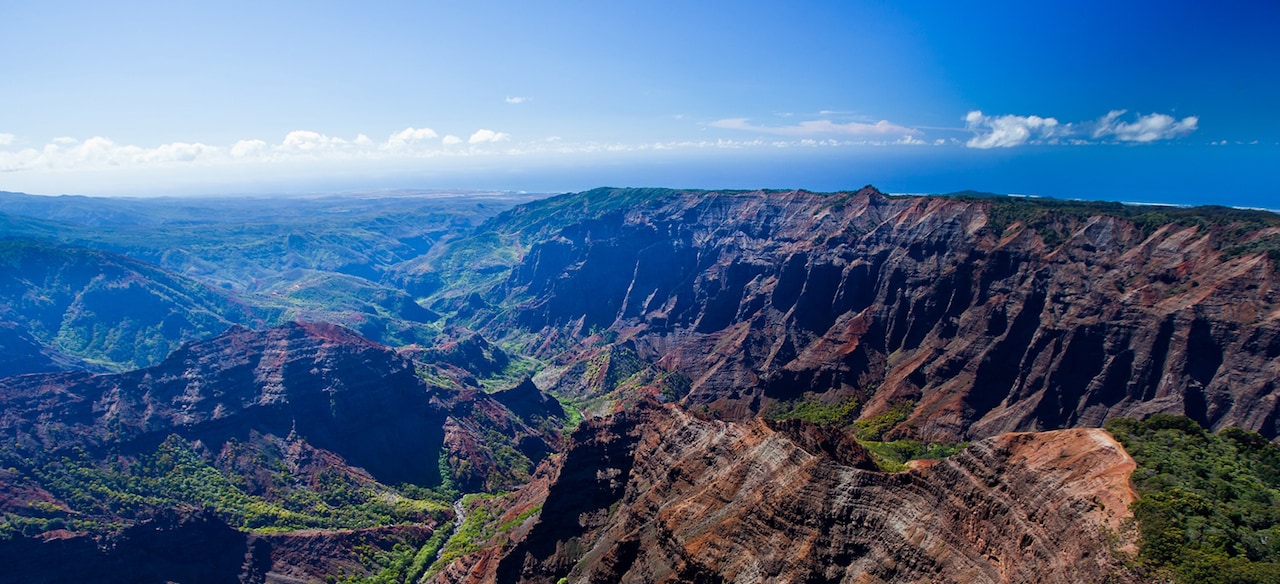 A sweeping panoramic view of rugged canyons and lush green valleys