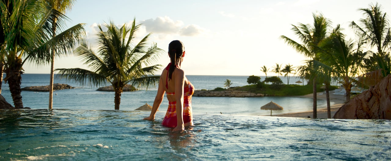 A female guest wearing a bathing suit enjoys a whirlpool spa while gazing at the clouds
