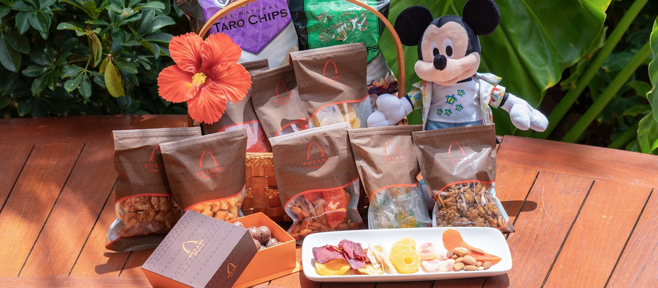 Packaged Hawaiian treats in 2 gift baskets featuring a plush of Mickey Mouse or Minnie Mouse