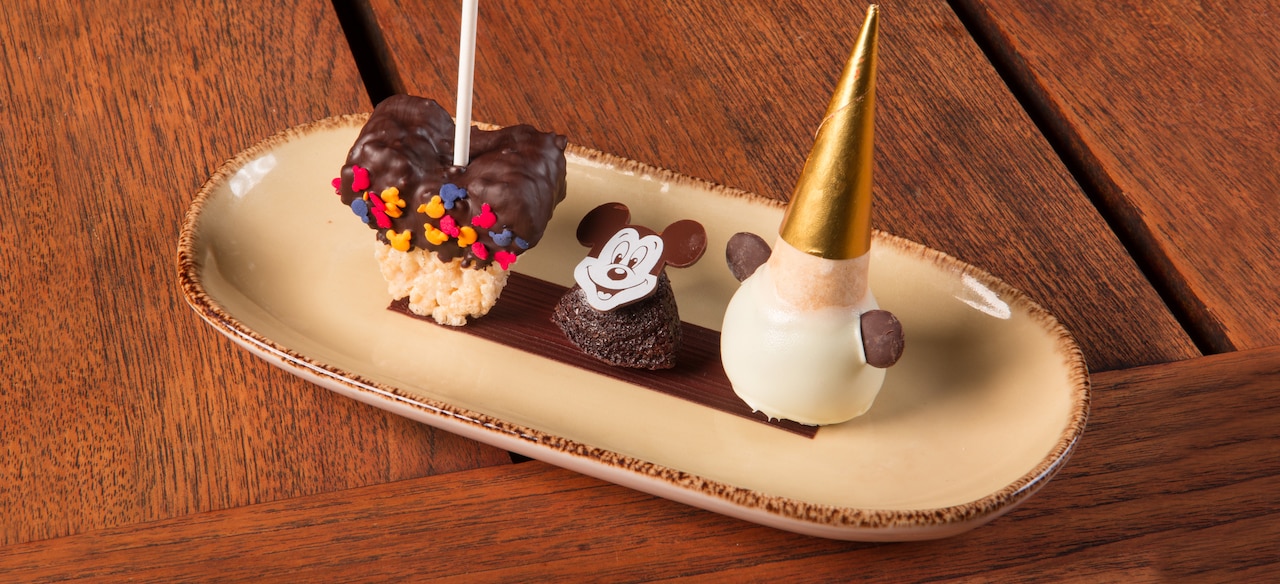 A crispy rice treat, a brownie and an ice-cream cone-shaped confection are presented on a platter.