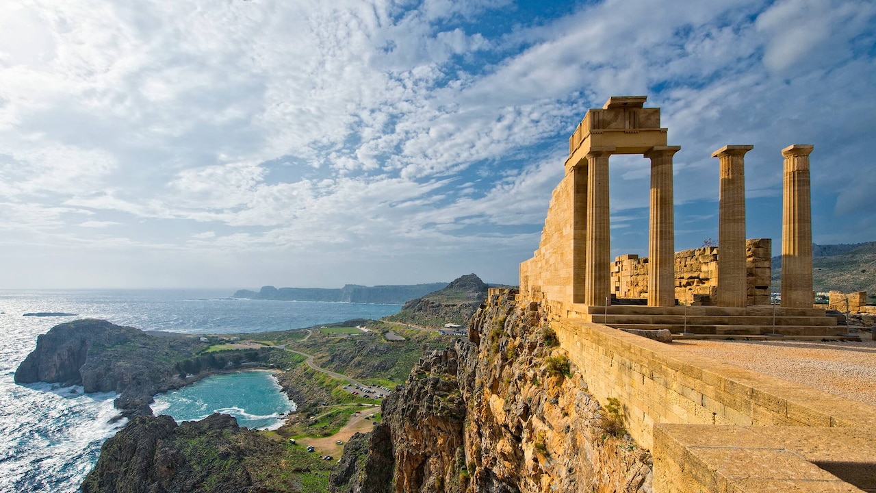 Ancient ruins with columns atop Acropolis overlooking the heart-shaped Bay of St. Paul and the Aegean Sea