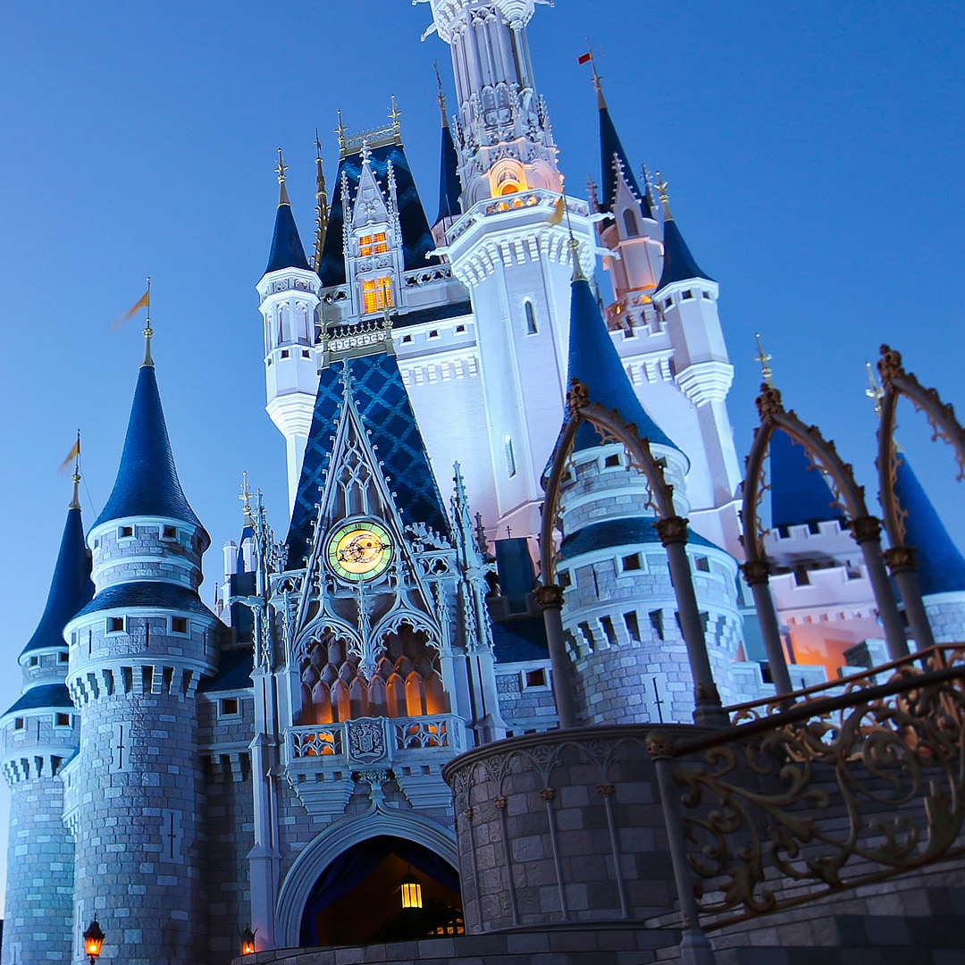 At dusk, lights shine from the windows of Cinderella Castle at Walt Disney World Resort