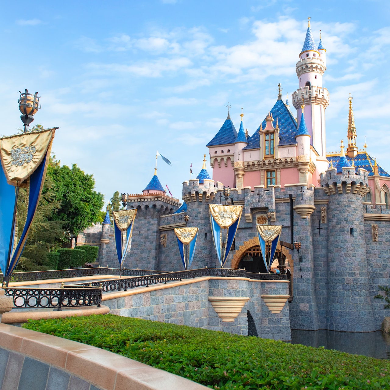 Surrounded by water, Sleeping Beauty Castle features a flag lined bridge leading up to its entrance