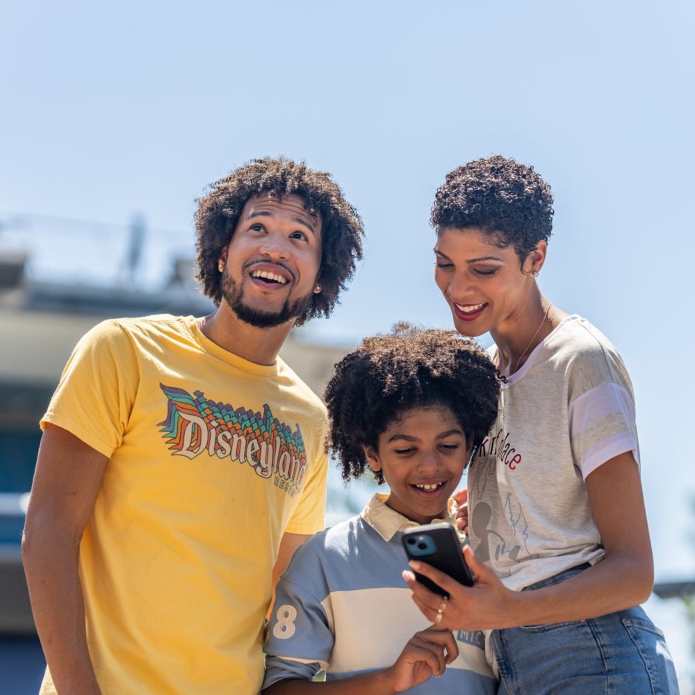 2 adults showing a child a phone 