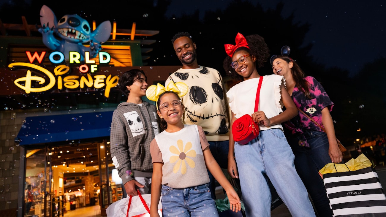 A family posing outside World of Disney at Disney Springs