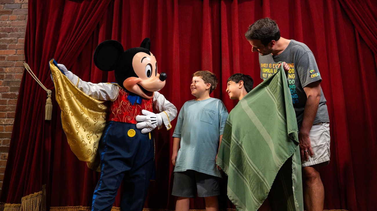 Two young boys and their father meeting Mickey Mouse  