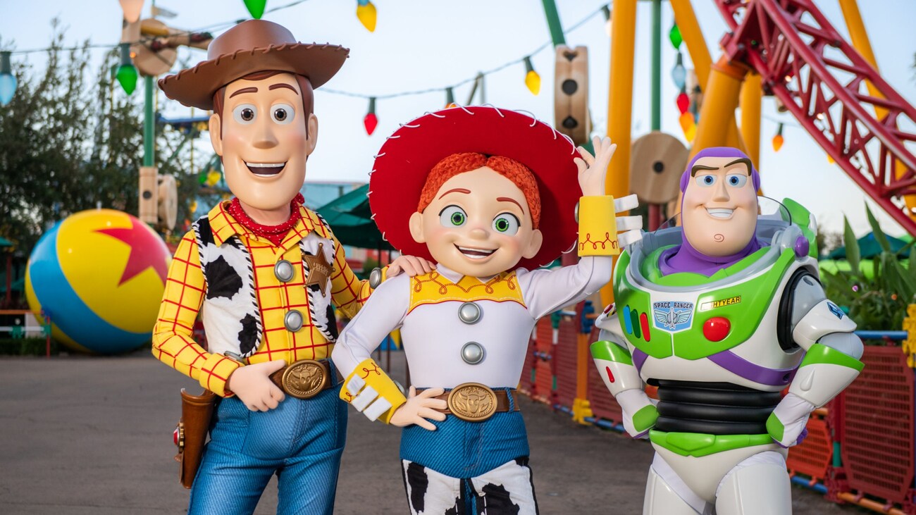  Jessie se quita el sombrero de vaquera mientras Woody y Buzz Lightyear posan a su lado frente a Toy Story Land en Disney’s Hollywood Studios.