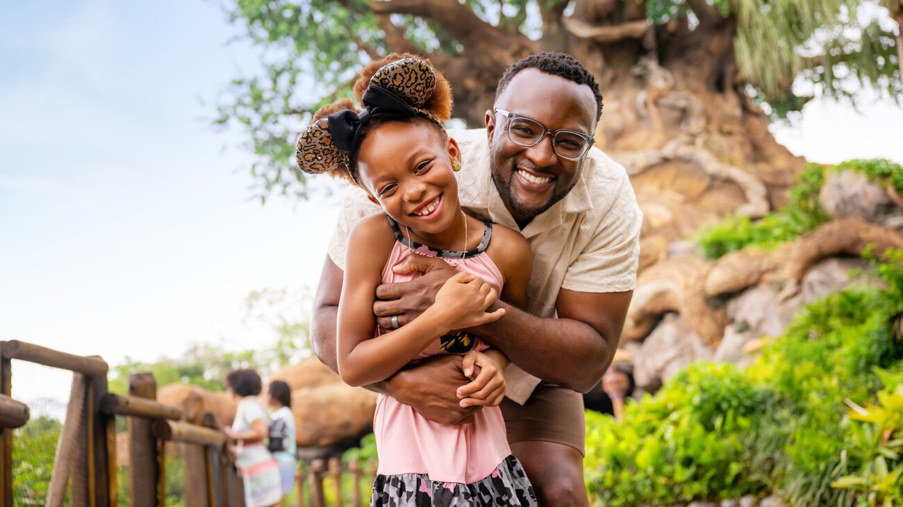 A father hugging his daughter in front of the Tree of Life at Disney’s Animal Kingdom theme park