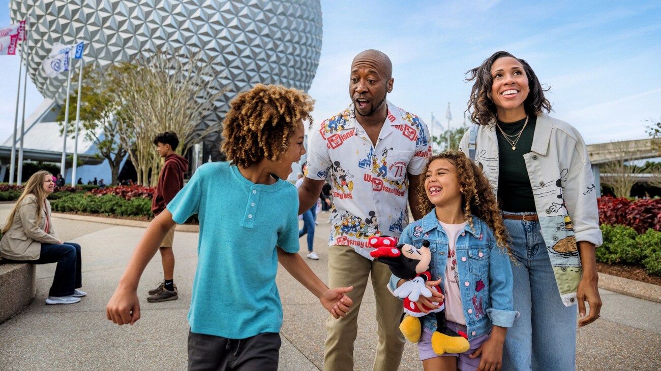 A family having a playful moment together in front of Spaceship Earth at Epcot