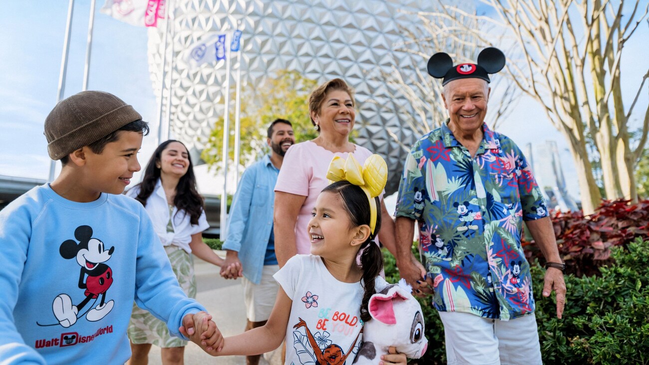 A multigenerational family walking in front of Spaceship Earth at Epcot