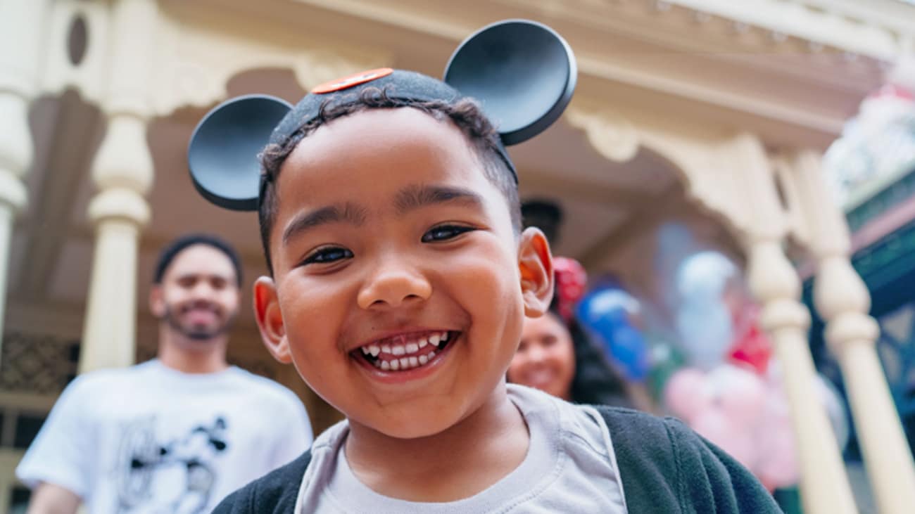 A young boy wearing a Mickey Mouse ears hat