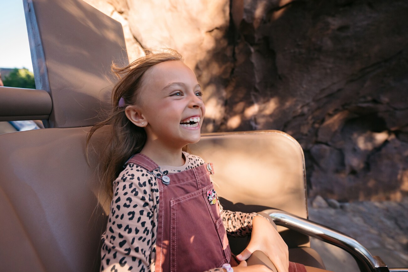 A young girl smiling while riding Expedition Everest at Disney’s Animal Kingdom theme park