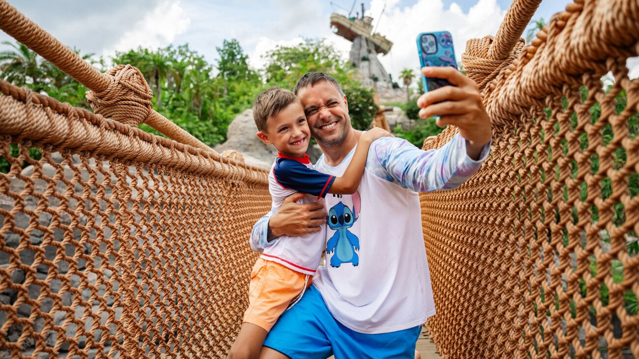 A father and son taking a selfie photo on a bridge at Disney’s Typhoon Lagoon water park