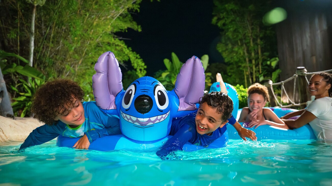 Two young Guests playing with a Stitch pool float during Disney H2O Glow After Hours at Disney’s Typhoon Lagoon 