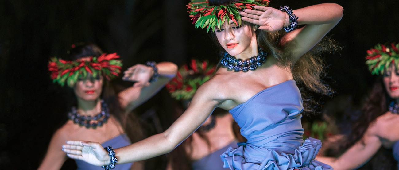 伝統的な衣装と葉っぱのヘッドドレスを身に着けて踊るハワイの女性たち（カ・ヴァア・ルアウ）。