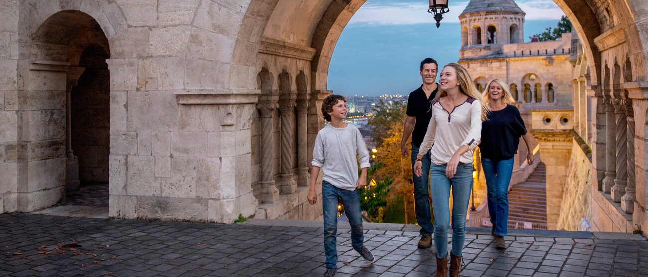 A city featuring a church with spires, skyscrapers and a covered bridge that spans the Rhine River