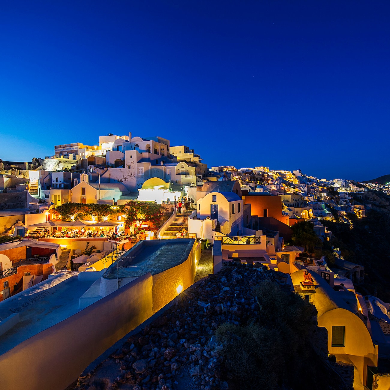The buildings of the city of Santorini, Greece lit up at nighttime