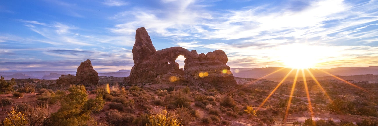 A sandstone arch in Arches National Park at sunrise