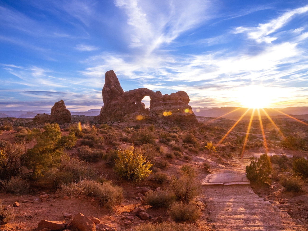 A sandstone arch in Arches National Park at sunrise