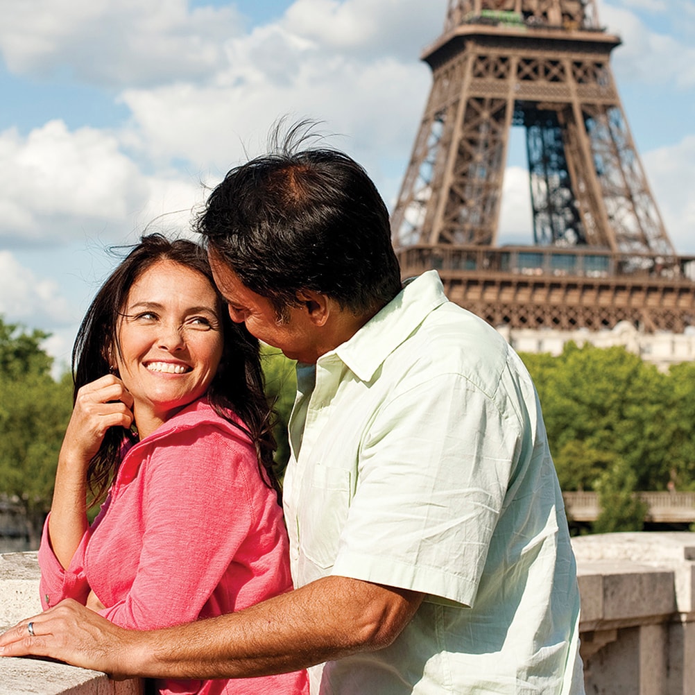 A couple gazes into each other’s eyes near the Eiffel Tower in Paris