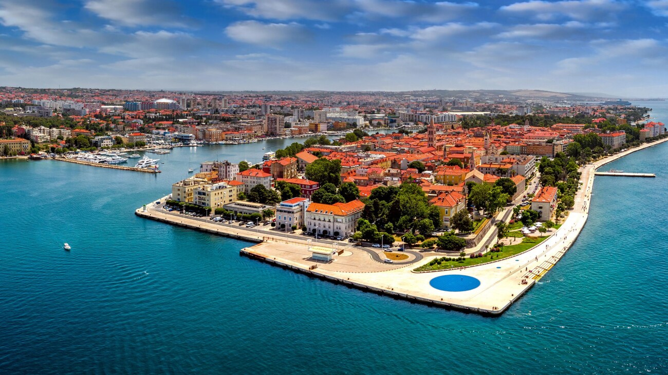 Zadar Old Town peninsula highlighted by the seafront walkway known as Riva promenade, surrounded on 3 sides by the Adriatic Sea