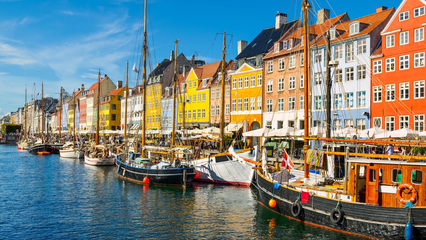 A historic waterfront lined with boats and gabled buildings