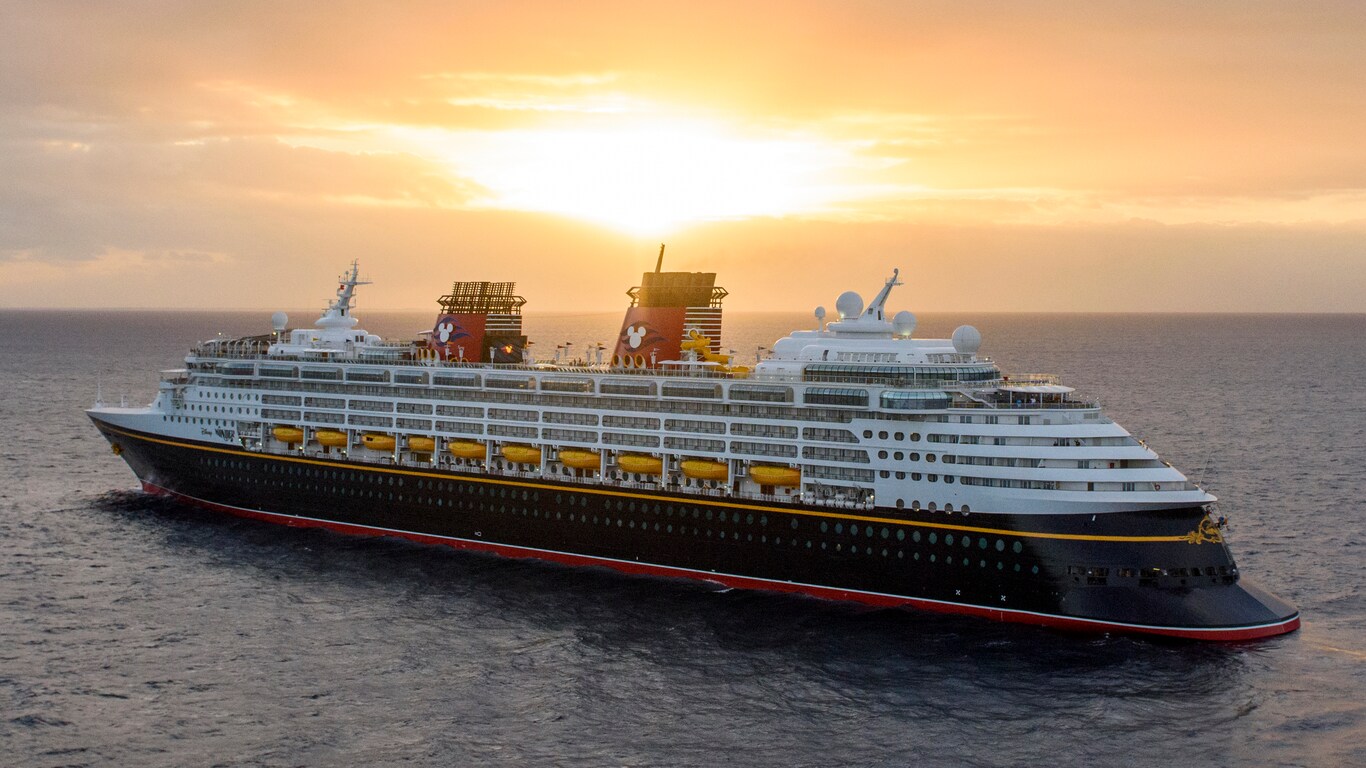A Disney cruise ship sails the open seas at sunset