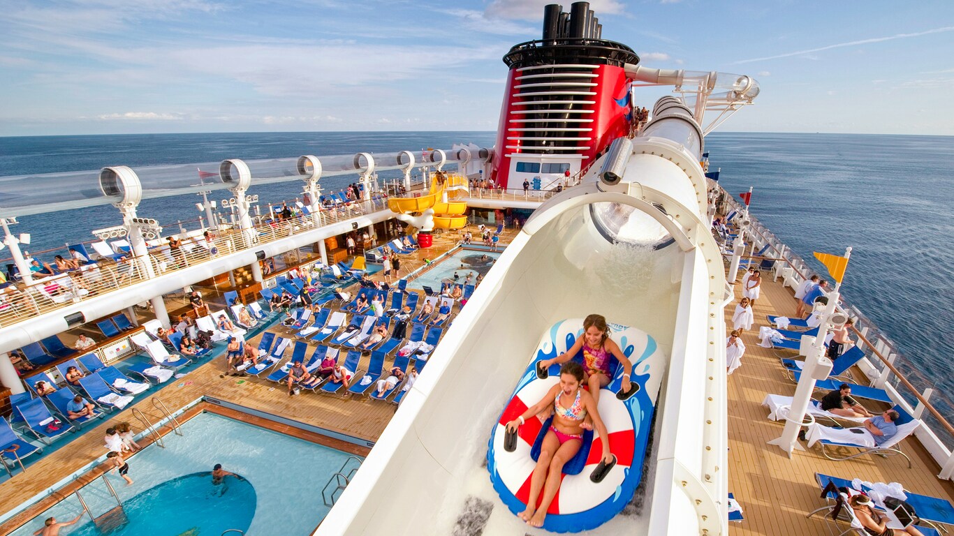 Two children in an inflatable raft propelling through the AquaDuck waterslide above the pool area