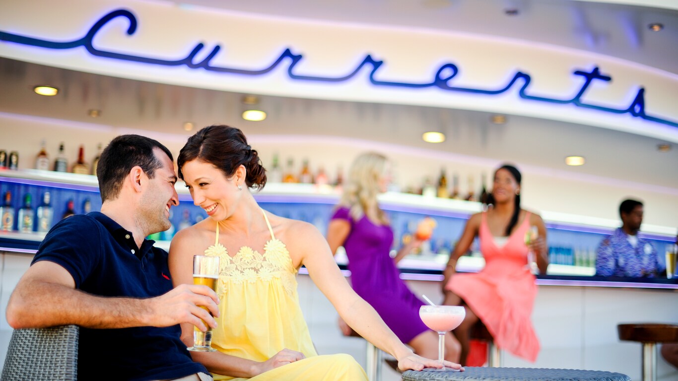 A man and a woman get cozy as they enjoy drinks at an outdoor lounge called Currents