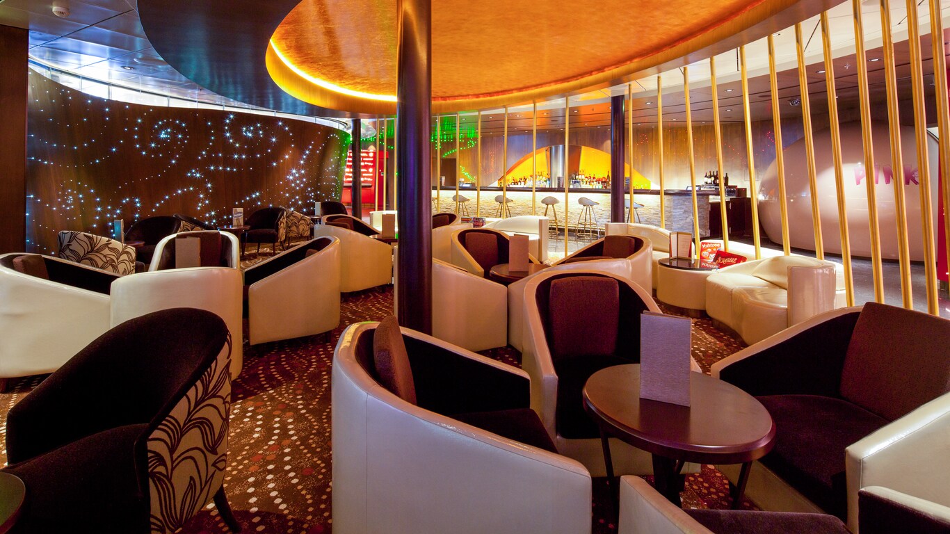 A lounge has 4 deep, rounded chairs around every cocktail table