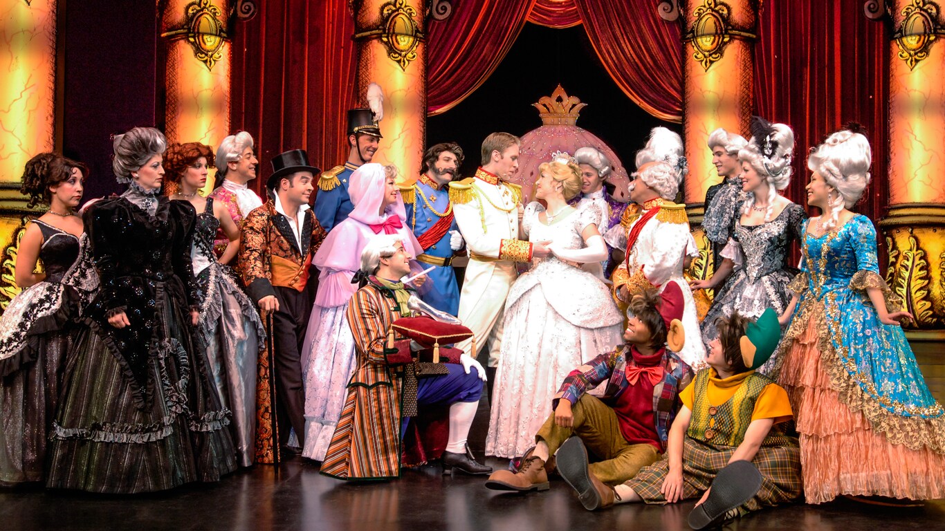 The Prince and Cinderella are surrounded by her evil stepmother and stepsisters and Fairy Godmother