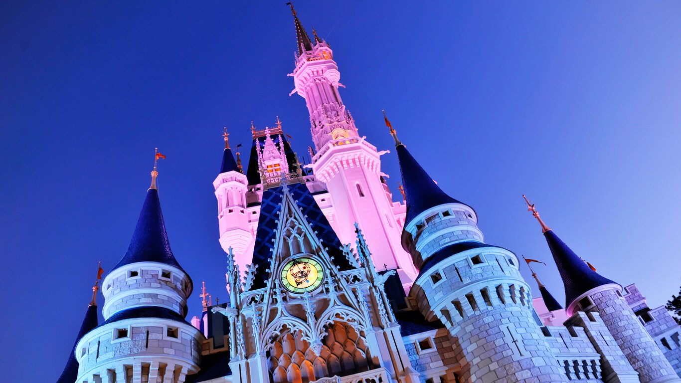 Cinderella Castle with its top spires bathed in pink light at night