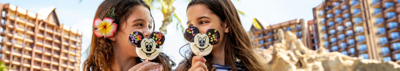 2 girls outside Aulani, A Disney Resort and Spa enjoy a Mickey Mouse ice cream bar