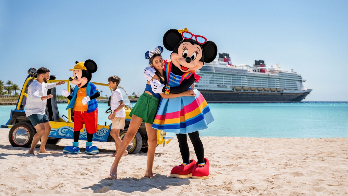 Mickey Mouse and Minnie Mouse greet a father and his teen son and daughter near a dune buggy on a beach