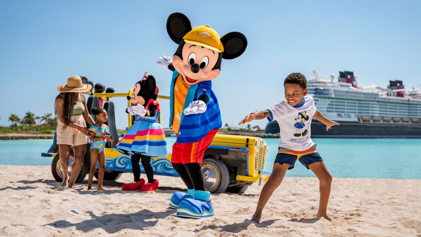 Mickey Mouse and young boy striking surfing poses on a beach while Minnie Mouse greets the family nearby with a Disney cruise ship in the background
