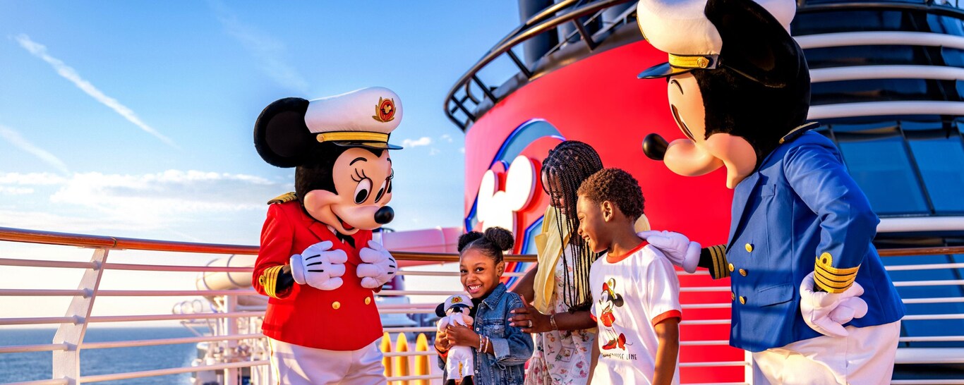 A family of 3 meeting Captain Mickey Mouse and Captain Minnie Mouse on a Disney Cruise Line ship