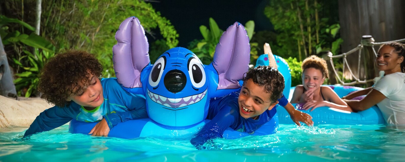 Two young Guests playing with a Stitch pool float during Disney H2O Glow After Hours at Disney’s Typhoon Lagoon  