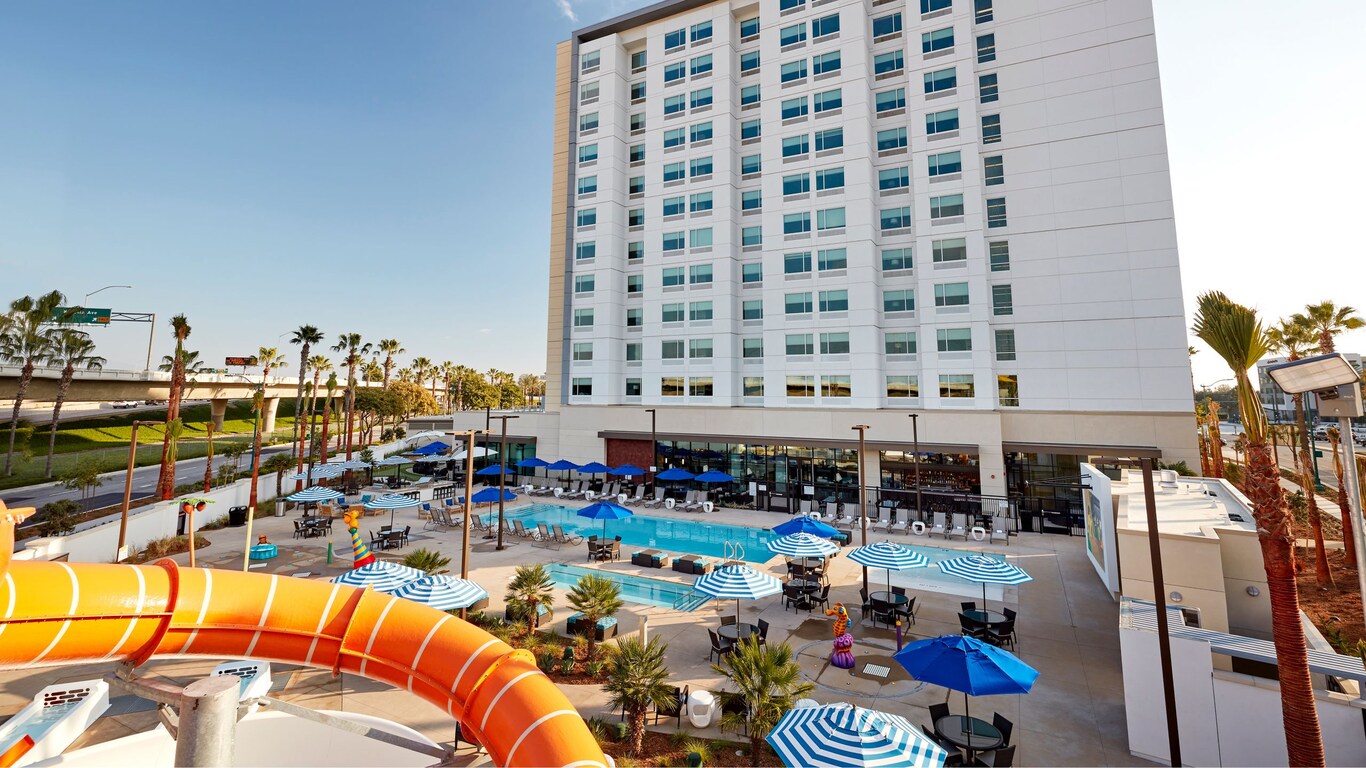 Anaheim Resort Suites hotel exterior with pool area featuring waterslides and striped umbrellas