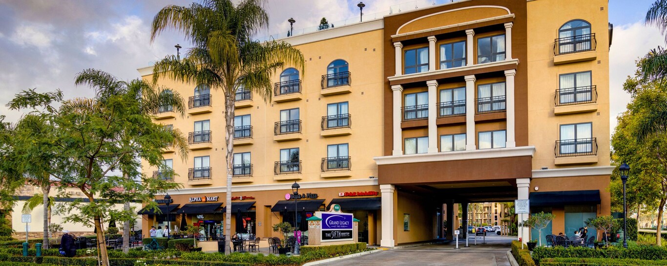 An outside view of the Grand Legacy at the Park with palm trees in front.