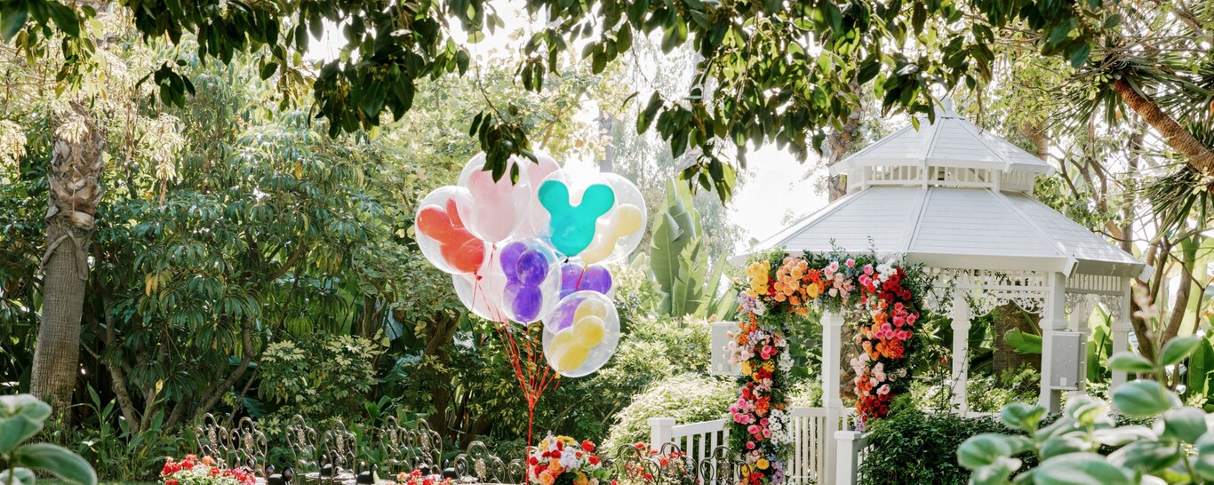  Un lugar para celebrar bodas con jardín, glorieta, arco floral, arreglos florales, sillas y globos de Mickey Mouse